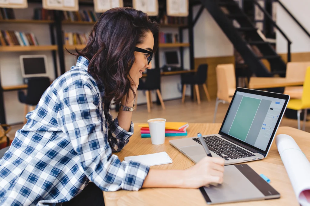 Female designer working on laptop and graphic tablet