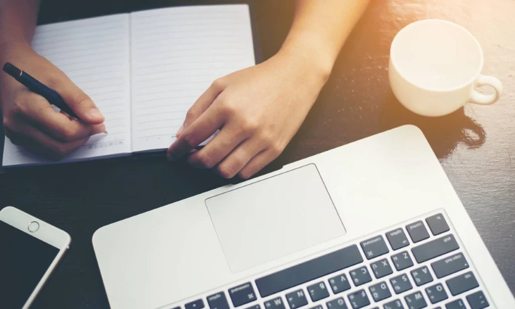 Writer working on laptop and notebook